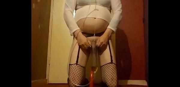  crossdressing sissy rides a dildo while drinking his own piss
